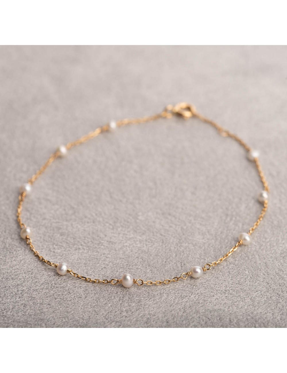 Bracelet femme orné de perle d'eau douce en or 9 carats.