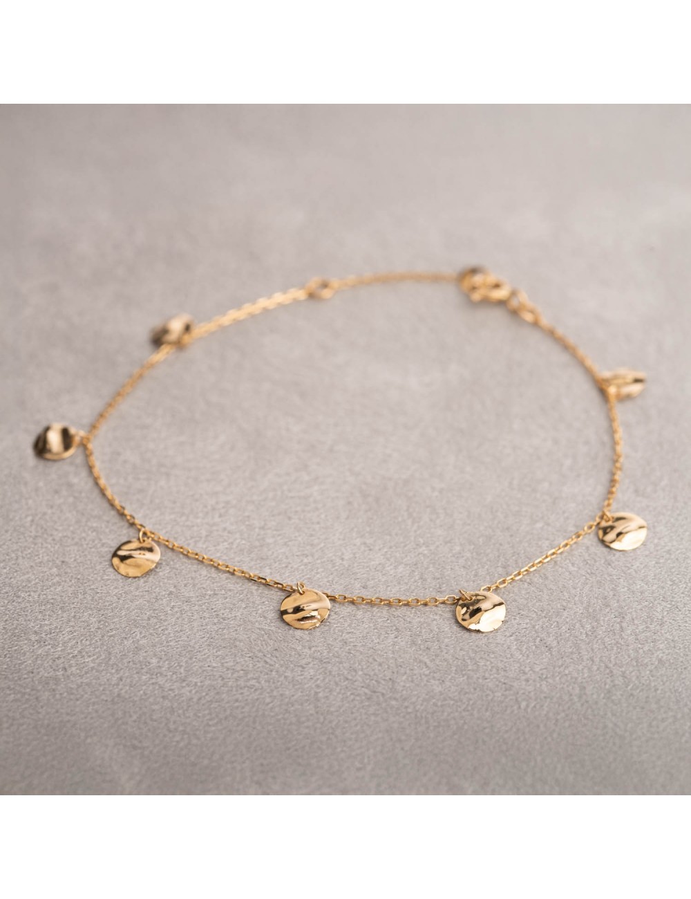 Bracelet femme orné de sept ronds froissés en breloque en or 18 carats.