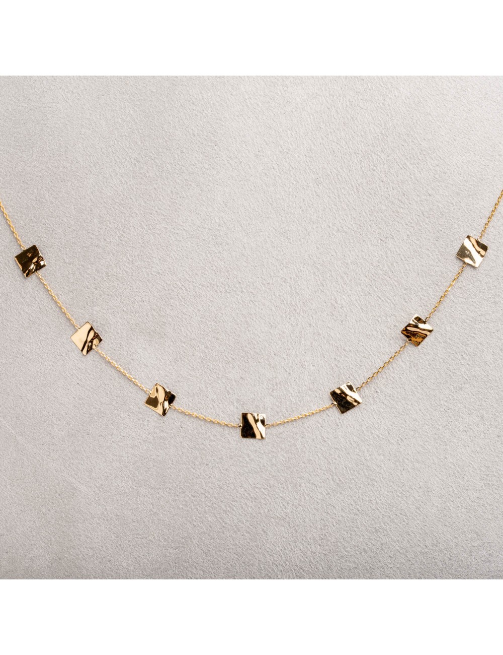 Collier femme orné de carré froissé en or 18 carats.